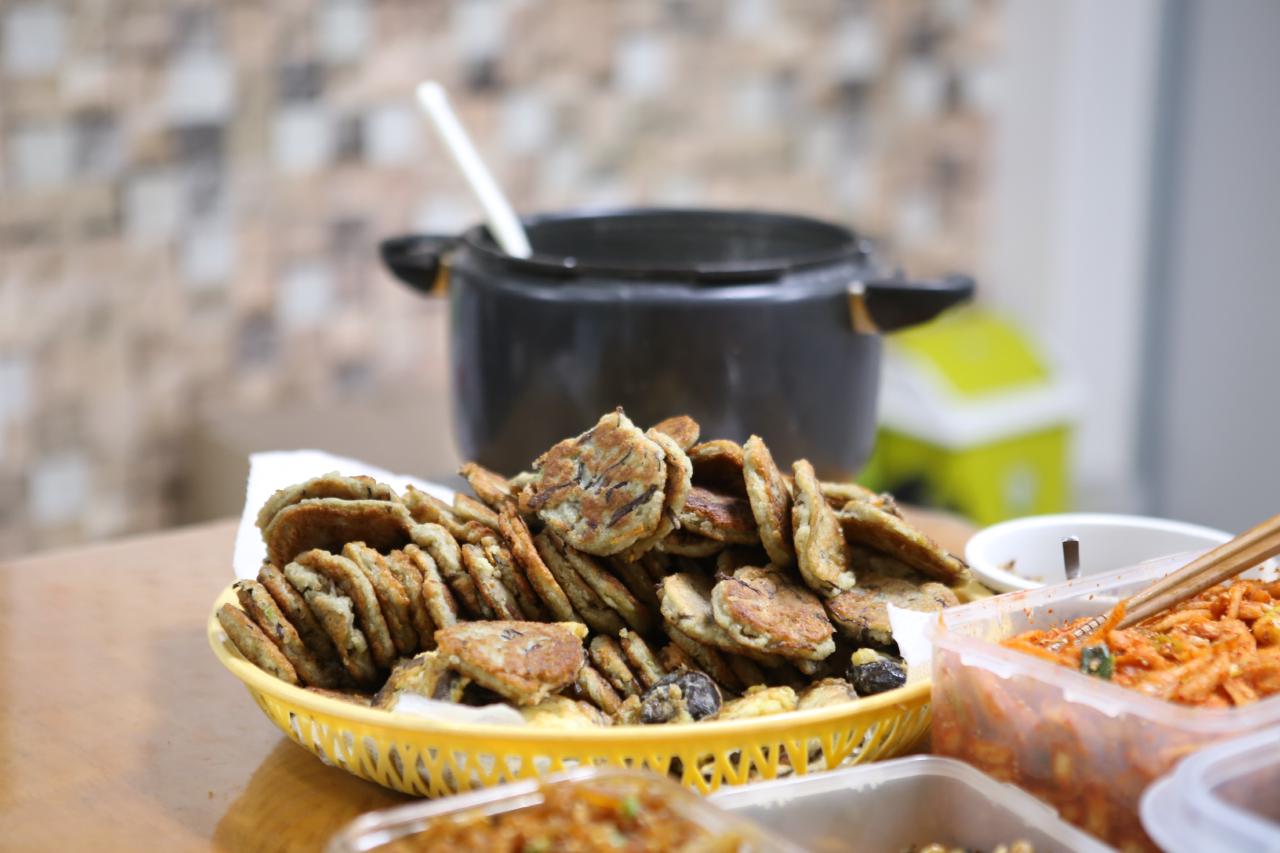 Alcuni jeon, tipiche fritelle coreane ripiene di carne, pesce o verdura, in una ciotola su di una tavola