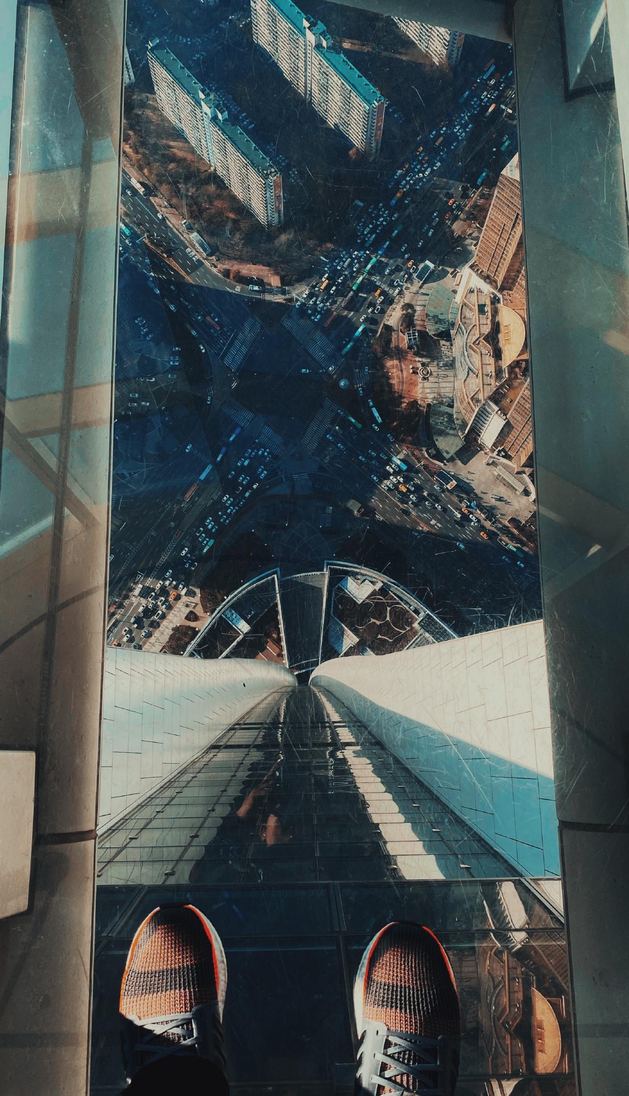 Foto della vista dalla cima della Lotte World Tower, guardando verso il basso attraverso la pavimentazione trasparente.