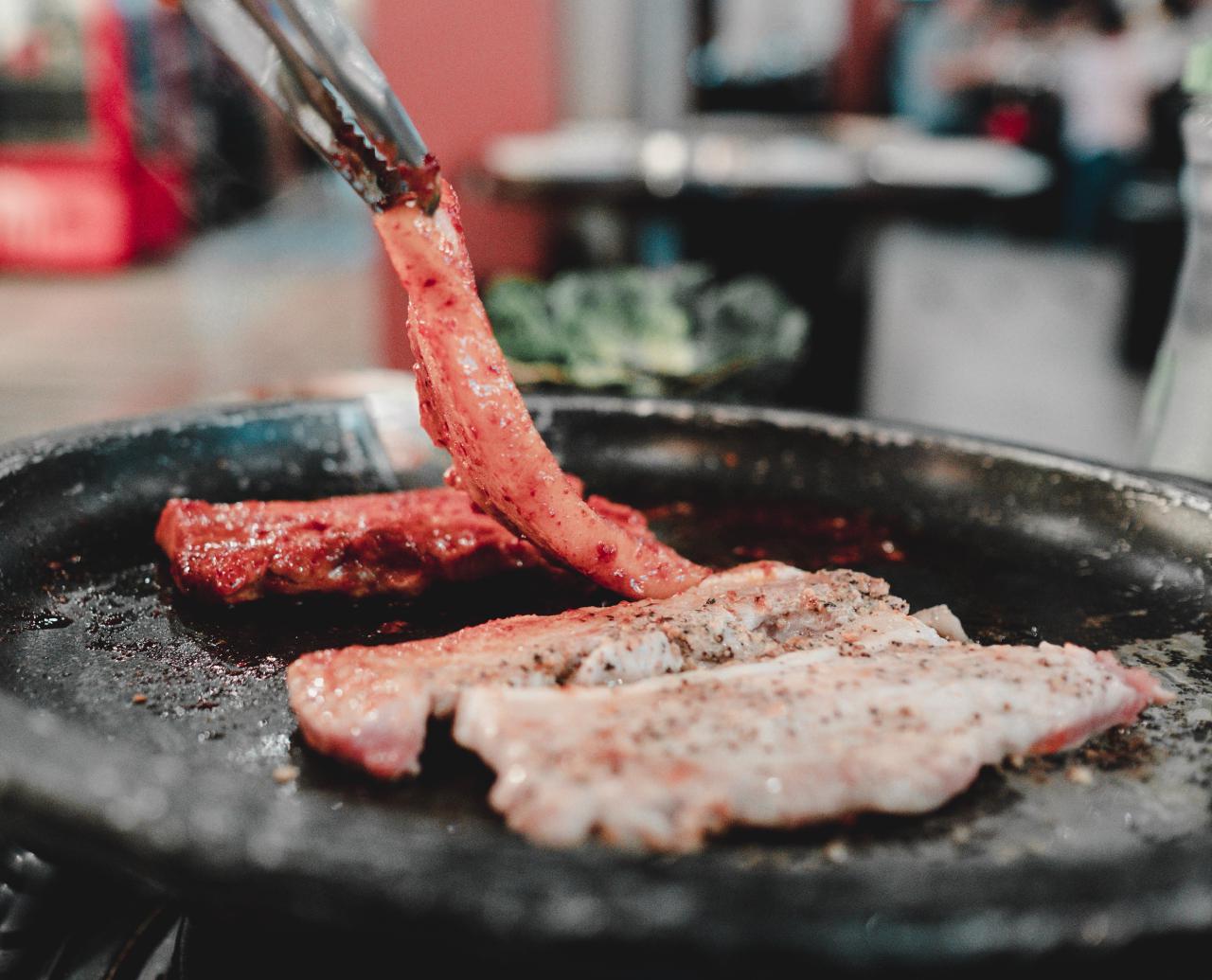 Il sam-gyeop-sal, o pancetta coreana, mentre viene arrostito sulla griglia di un ristorante